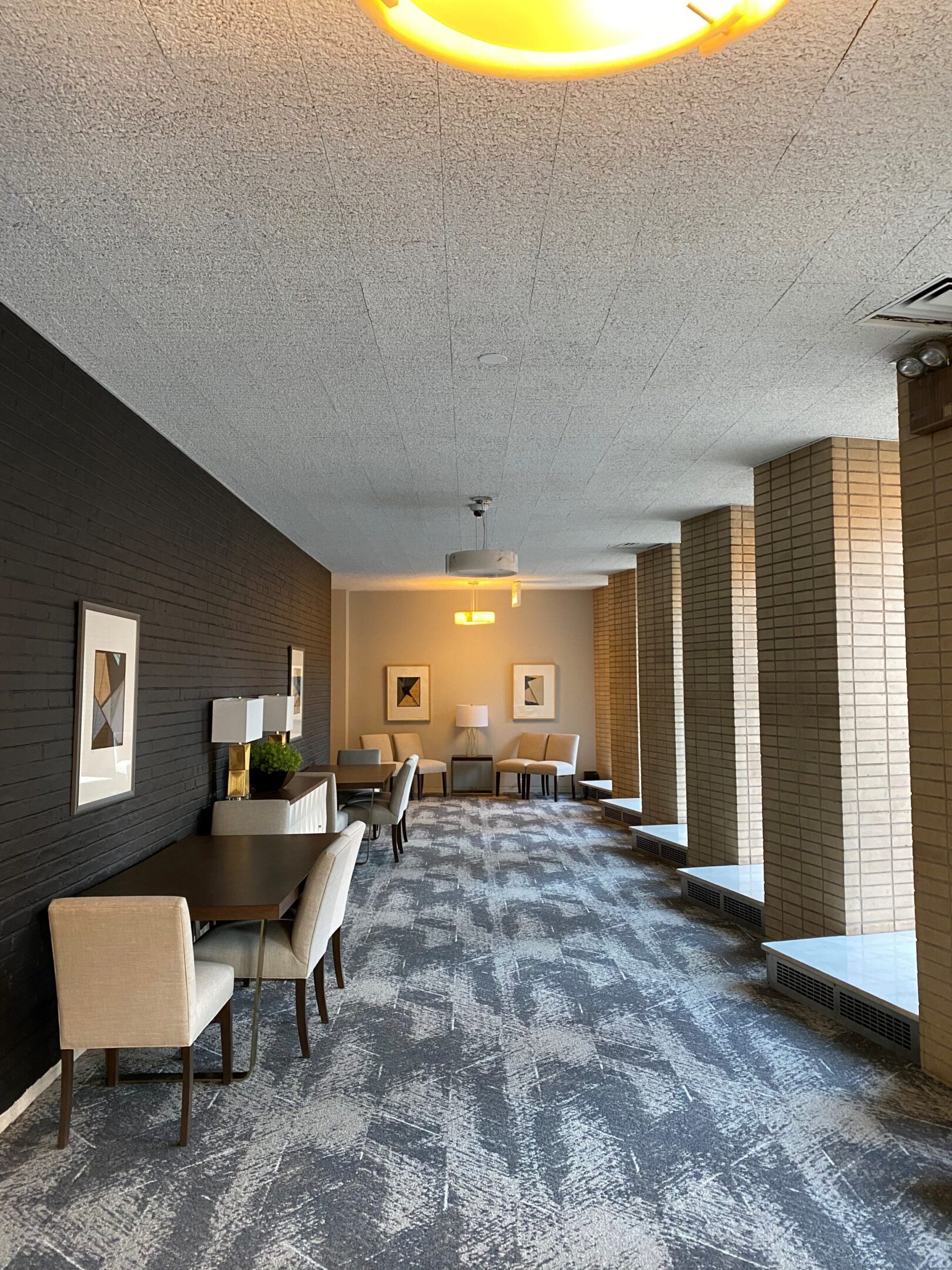 Modern hallway with seating and artwork along the walls.