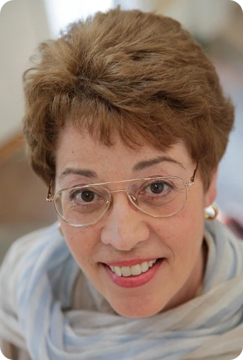 Smiling woman with glasses and short hair.